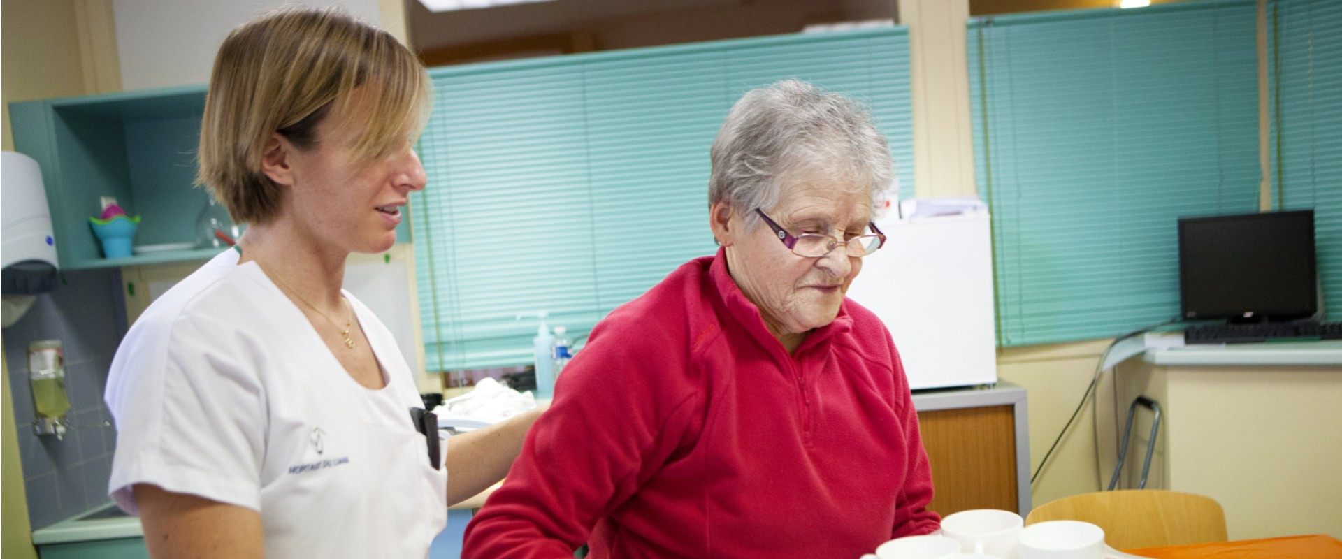 A nurse assisting a patient carrying some cups